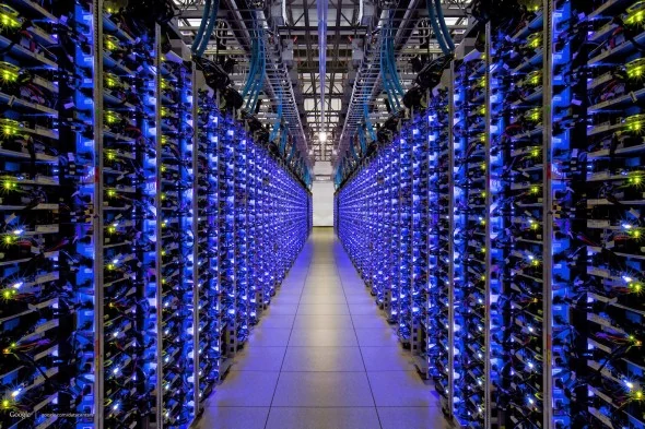 Corredor de um data center com racks iluminados — imagem de banco de imagens usada pela Sastrac para ilustrar a hospedagem na AWS